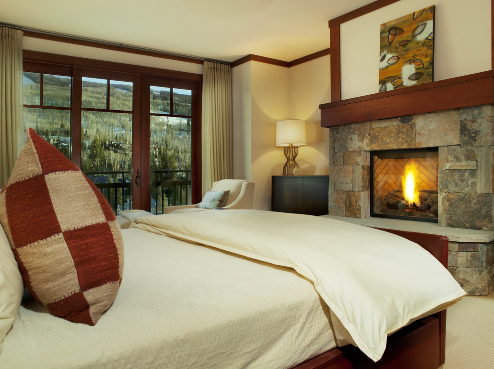 Inspiration for a contemporary carpeted bedroom remodel in Denver with beige walls, a standard fireplace and a stone fireplace
