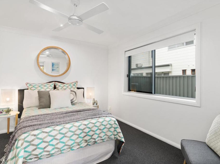 Immagine di una camera degli ospiti costiera di medie dimensioni con pareti bianche, moquette e pavimento grigio