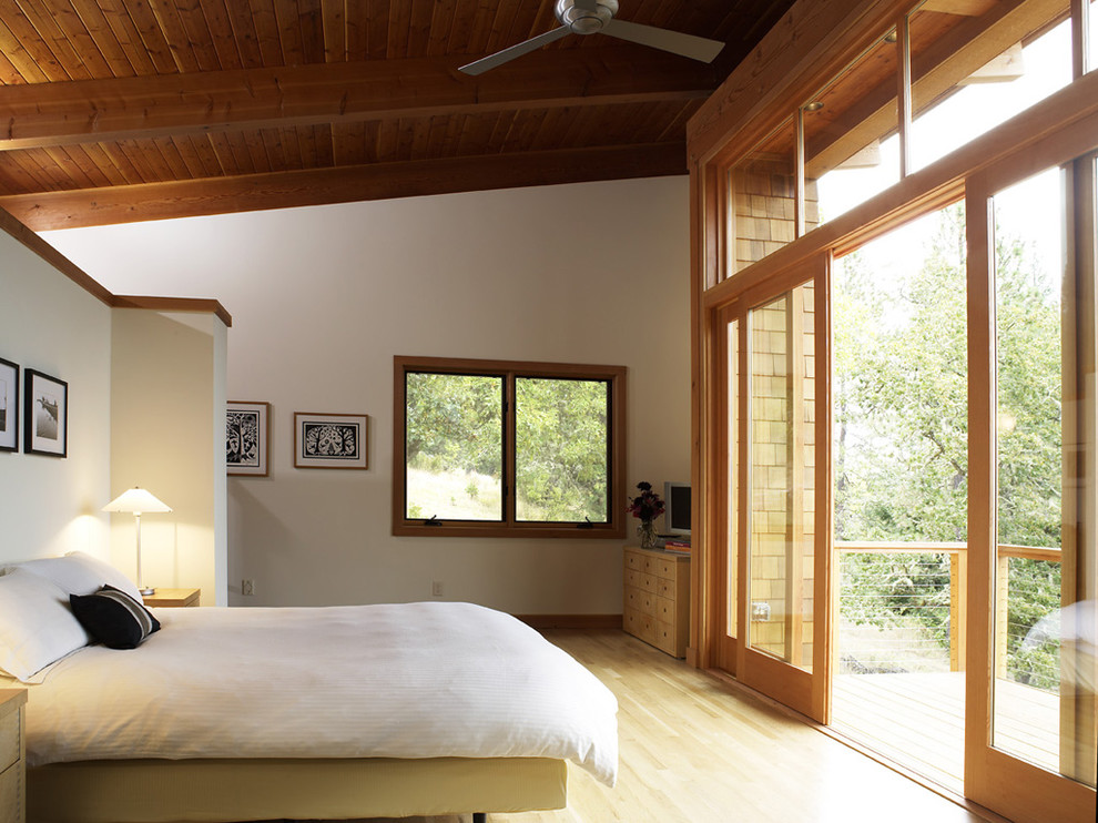 Photo of a rustic bedroom in Portland with white walls and light hardwood flooring.