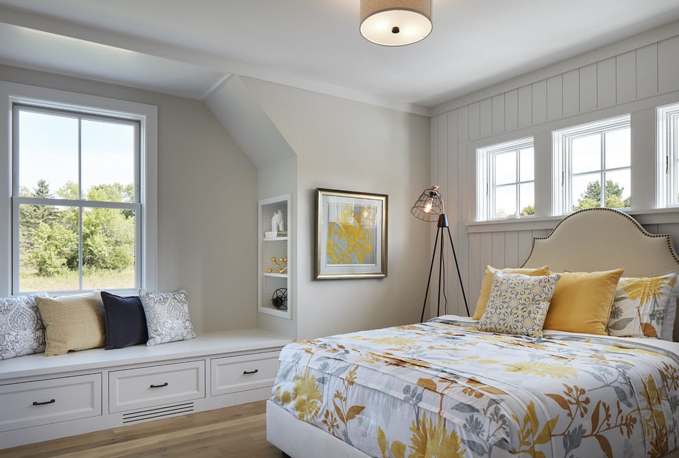 Modelo de habitación de invitados de estilo de casa de campo de tamaño medio con suelo de madera clara, paredes grises y suelo marrón
