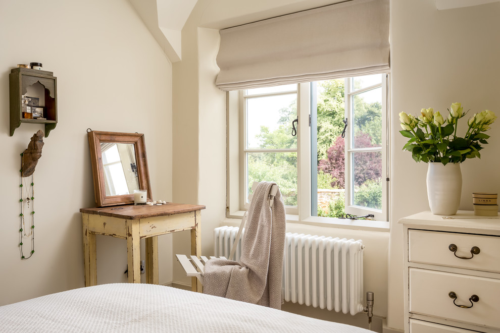 This is an example of a medium sized rural master bedroom in Gloucestershire with beige walls and no fireplace.