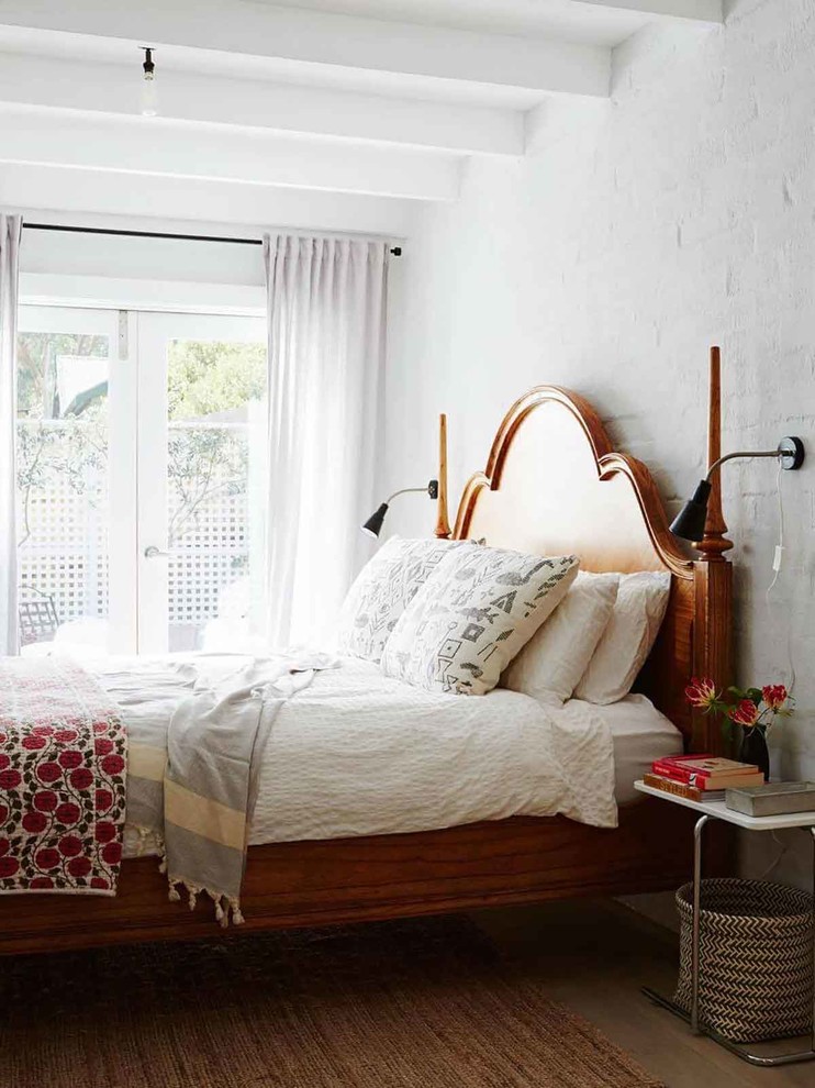Modelo de dormitorio tradicional renovado con paredes blancas y suelo marrón