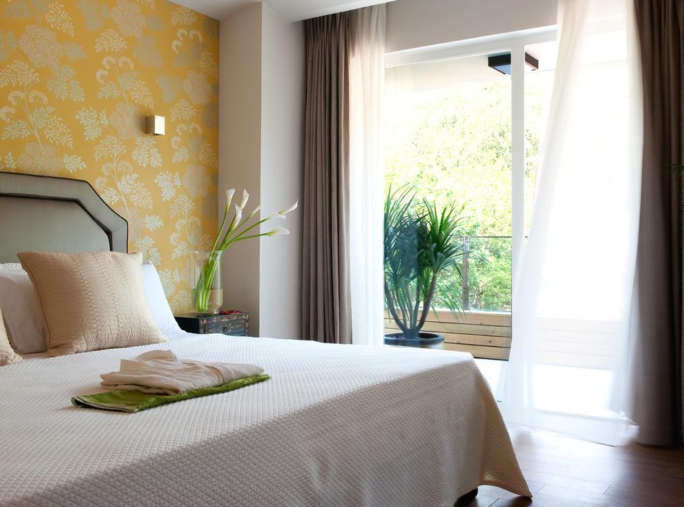 Ejemplo de dormitorio principal moderno grande con paredes amarillas y suelo de bambú