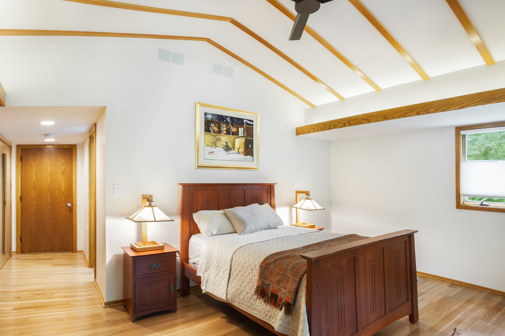 Imagen de dormitorio principal de estilo americano de tamaño medio con paredes blancas y suelo de madera clara
