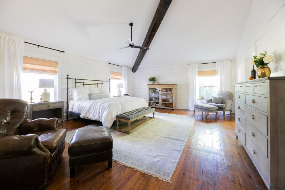 Ejemplo de dormitorio principal campestre grande con paredes blancas, suelo de madera en tonos medios y suelo marrón