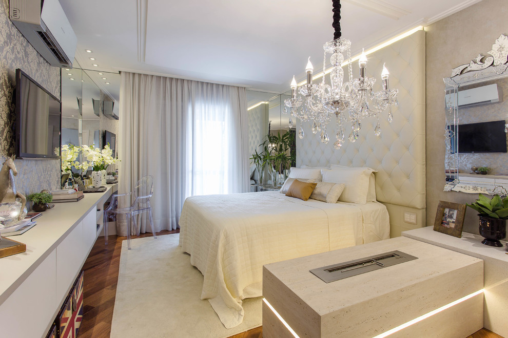 Diseño de dormitorio televisión actual con suelo de madera en tonos medios
