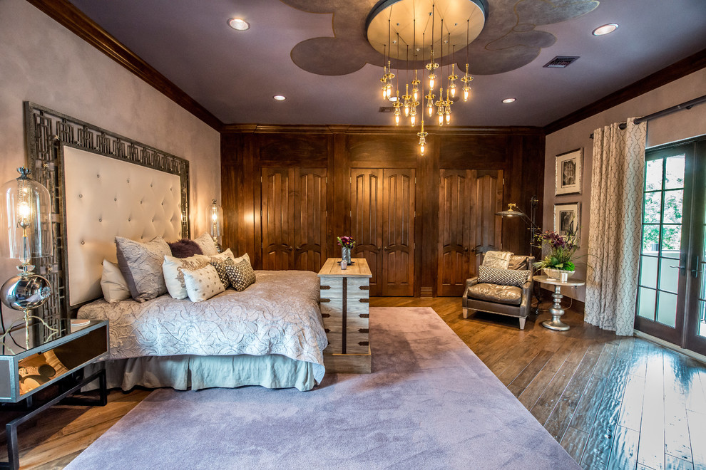 Foto di una camera da letto mediterranea con pareti viola e pavimento in legno massello medio