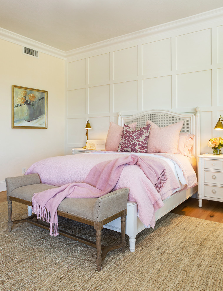 Modelo de dormitorio principal clásico de tamaño medio sin chimenea con paredes blancas, suelo de madera clara y suelo marrón