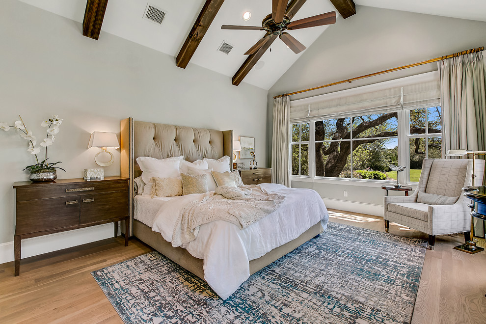 Inspiration for a large classic master bedroom in Austin with medium hardwood flooring, brown floors and grey walls.