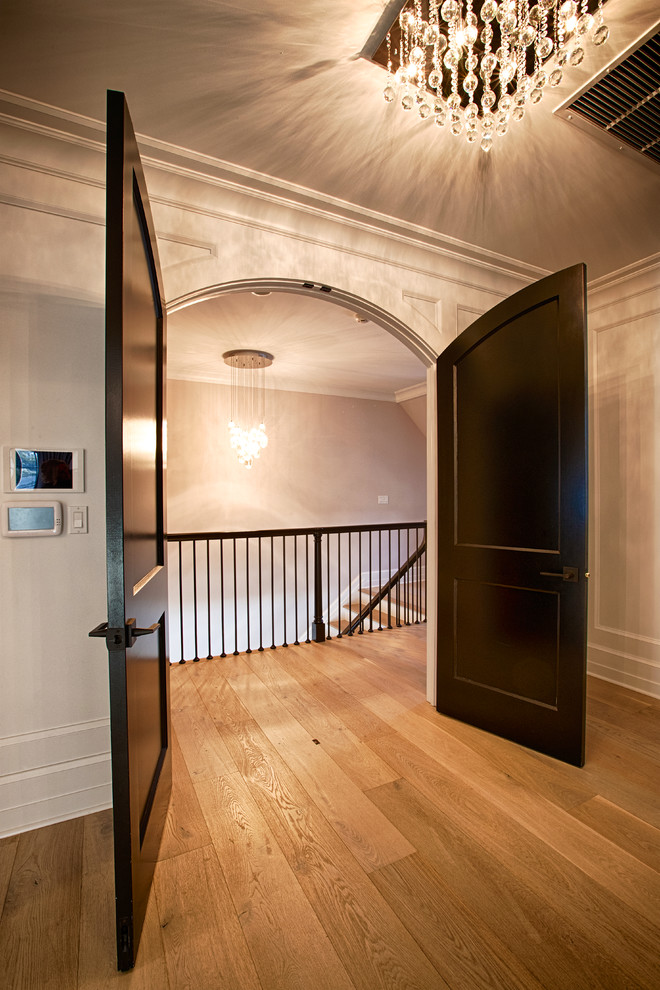 ニューヨークにある広いトランジショナルスタイルのおしゃれな主寝室 (グレーの壁、無垢フローリング、暖炉なし、茶色い床、グレーとブラウン)