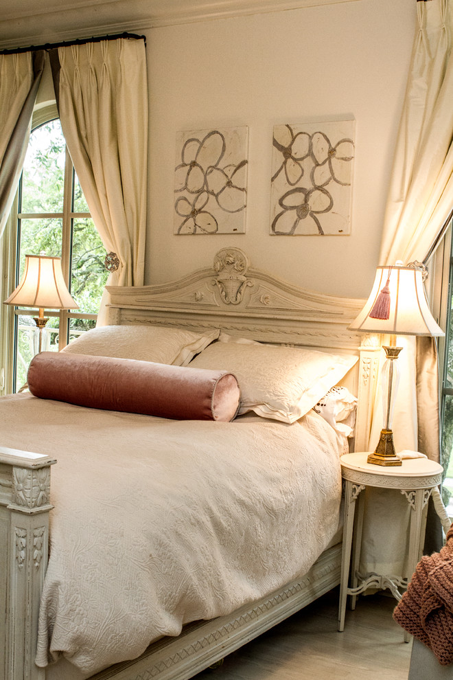 This is an example of a large vintage master and grey and cream bedroom in New Orleans with white walls and dark hardwood flooring.