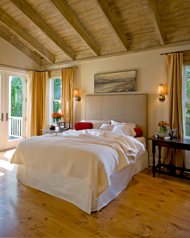 Immagine di una camera da letto con pareti beige, pavimento in legno massello medio e pavimento giallo