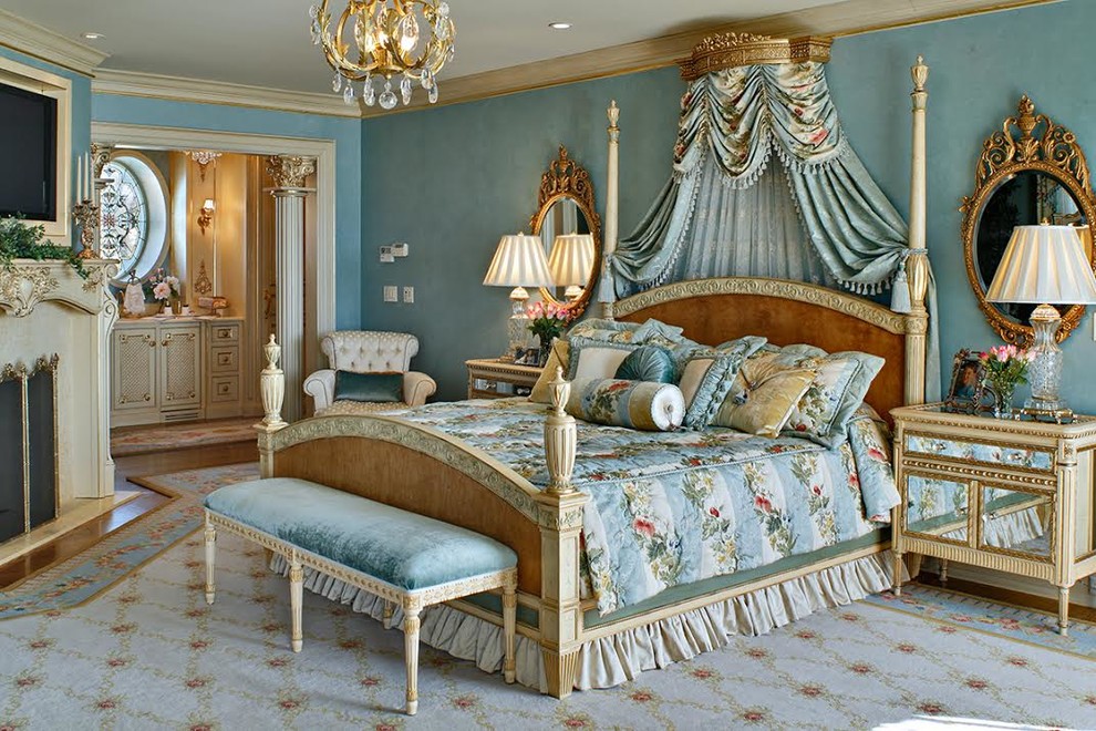 Ejemplo de dormitorio principal clásico de tamaño medio con paredes azules, todas las chimeneas, marco de chimenea de piedra, suelo beige y suelo de madera clara