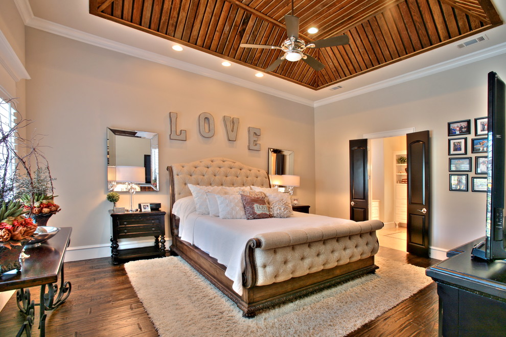 This is an example of a medium sized traditional master bedroom in Dallas with beige walls and dark hardwood flooring.