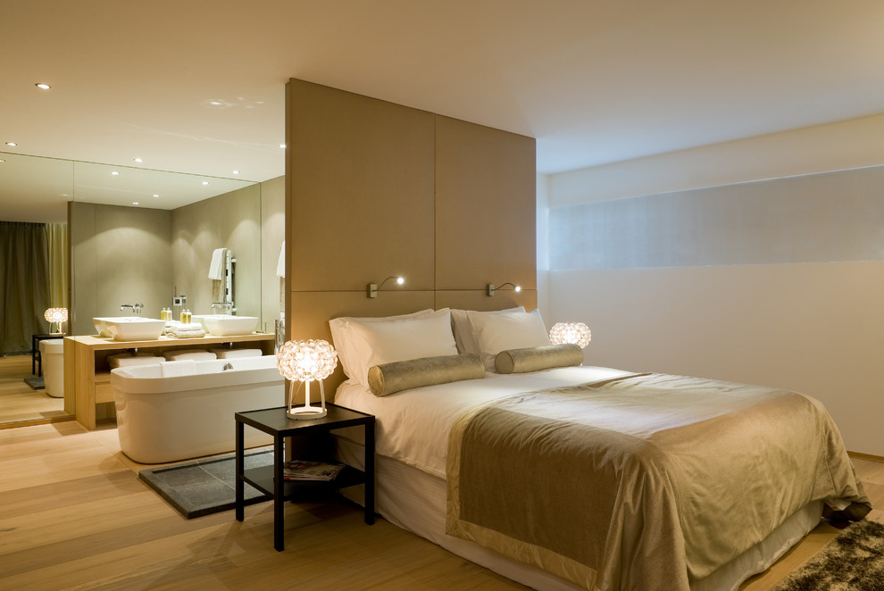 Großes Modernes Hauptschlafzimmer mit weißer Wandfarbe und hellem Holzboden in Sonstige