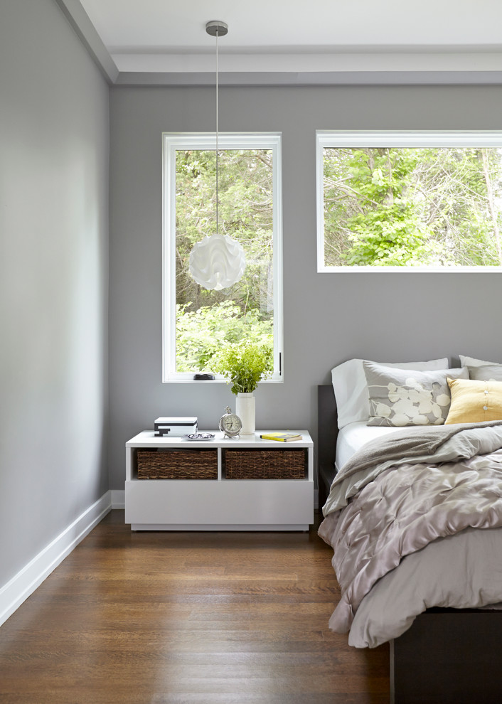Inspiration pour une chambre design avec un mur gris et parquet foncé.