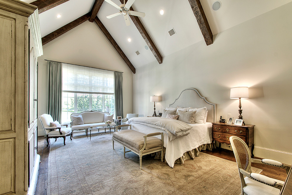Klassisches Hauptschlafzimmer ohne Kamin mit weißer Wandfarbe und dunklem Holzboden in Houston