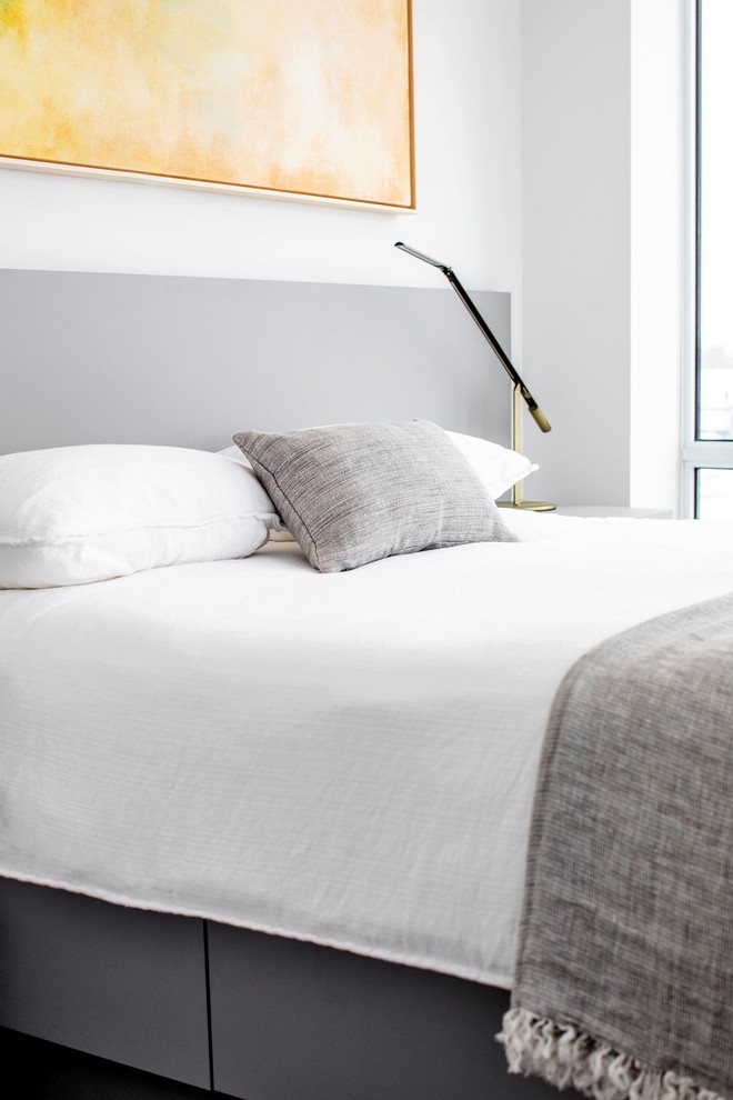 Foto de dormitorio principal minimalista pequeño con paredes blancas, suelo laminado y suelo marrón