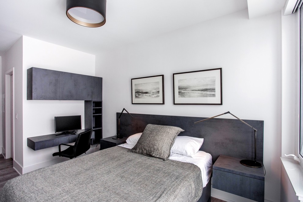 Ejemplo de dormitorio principal moderno pequeño con paredes blancas, suelo laminado y suelo marrón