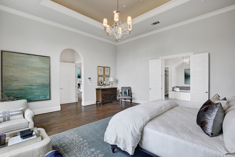 Large mediterranean master bedroom in Dallas with grey walls, medium hardwood flooring and brown floors.