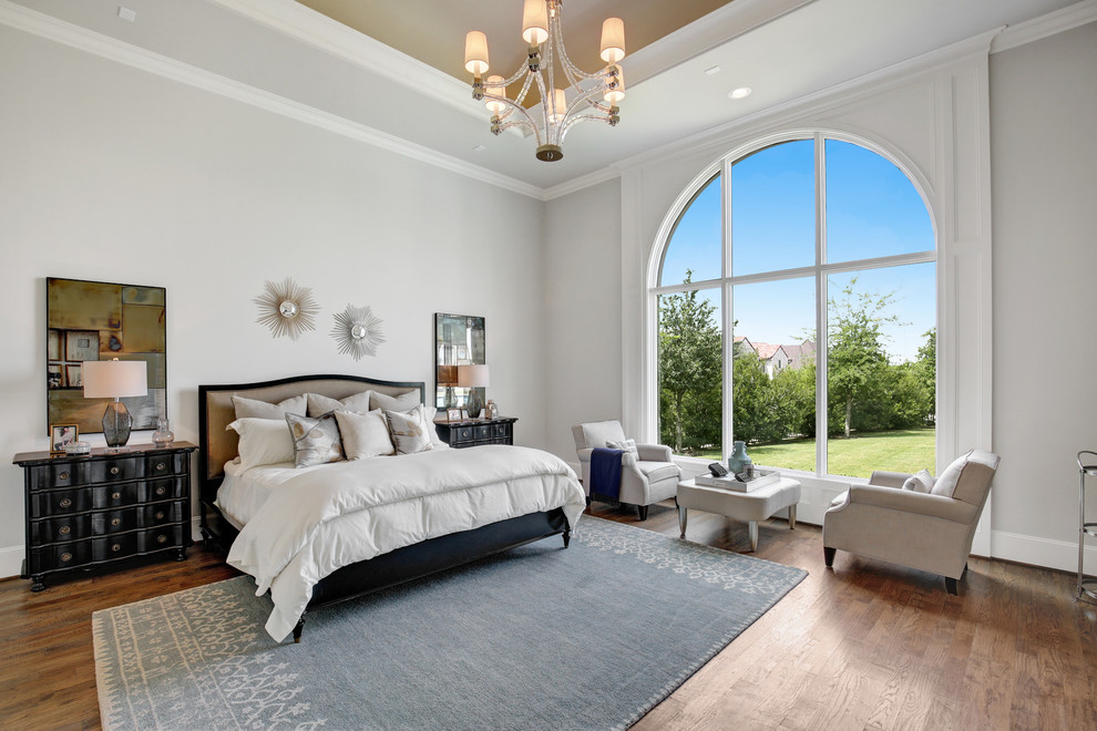 Photo of a large mediterranean master and grey and brown bedroom in Dallas with grey walls, medium hardwood flooring and brown floors.