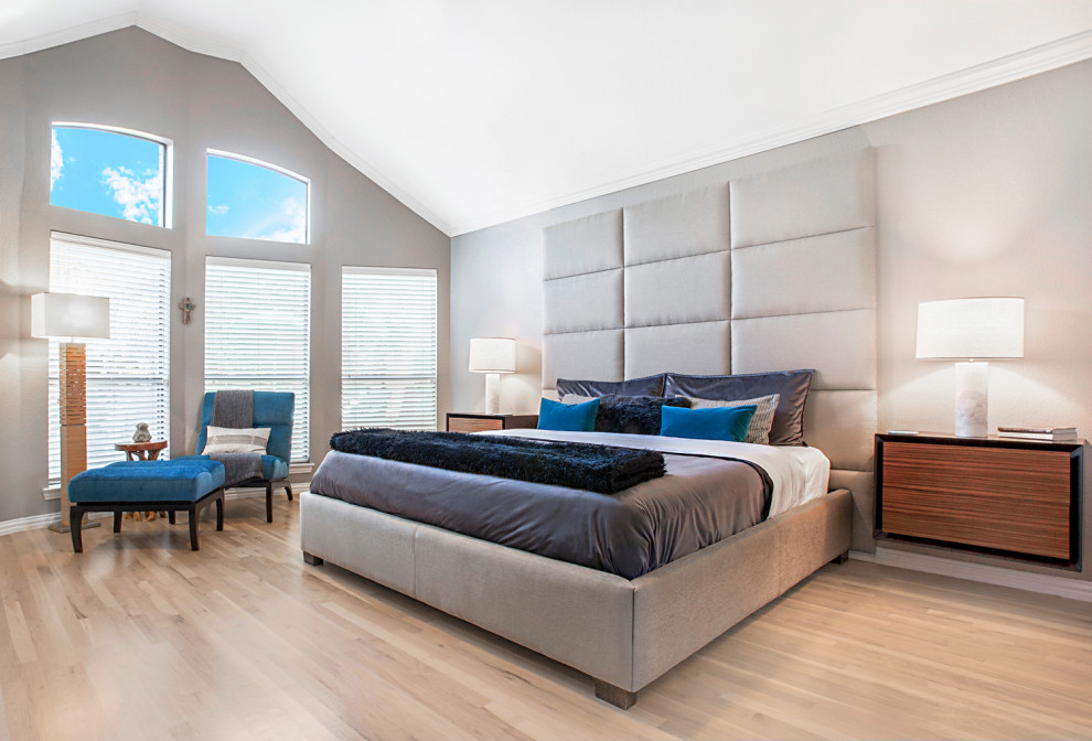 Modelo de dormitorio principal y abovedado minimalista de tamaño medio con paredes grises y suelo de madera clara