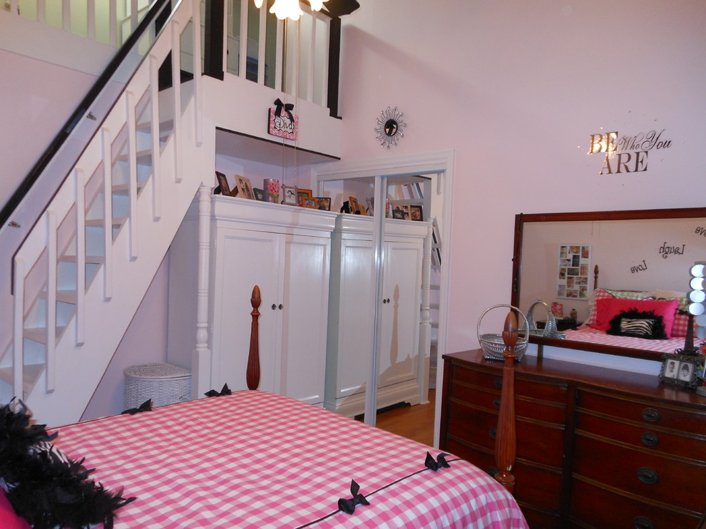 Ejemplo de dormitorio tipo loft clásico renovado con paredes rosas y suelo de madera en tonos medios