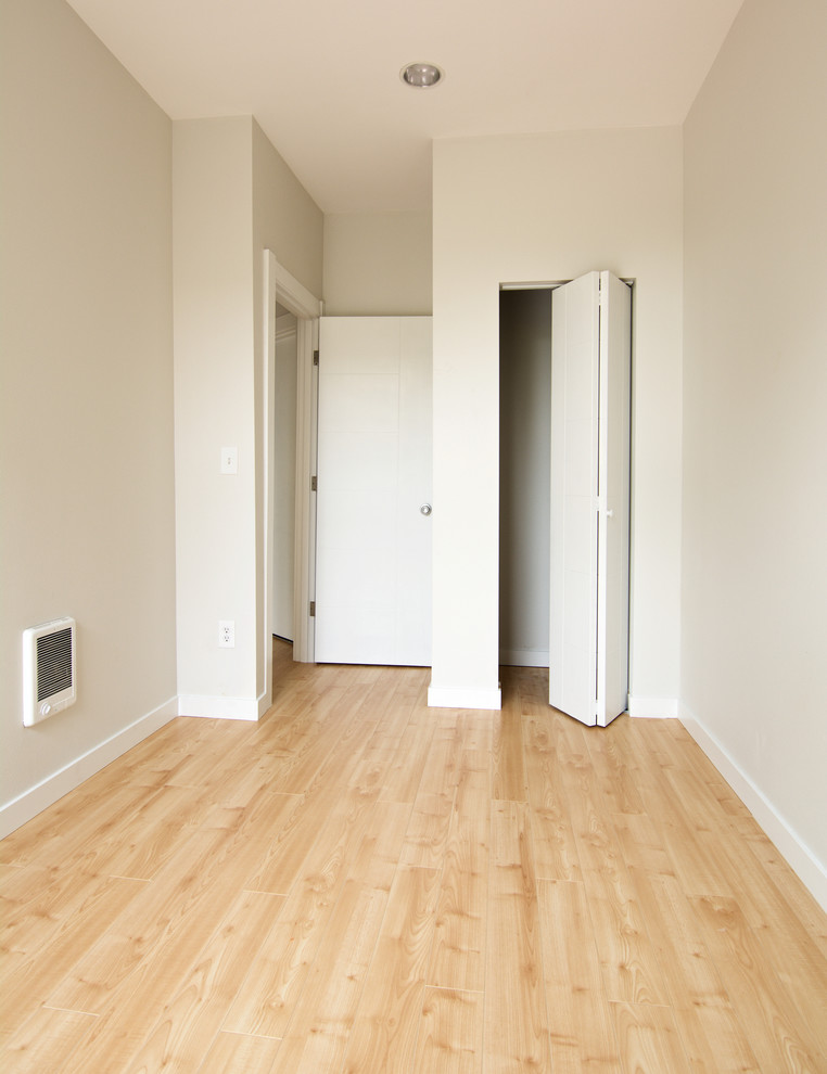 Imagen de habitación de invitados minimalista pequeña sin chimenea con paredes blancas y suelo amarillo