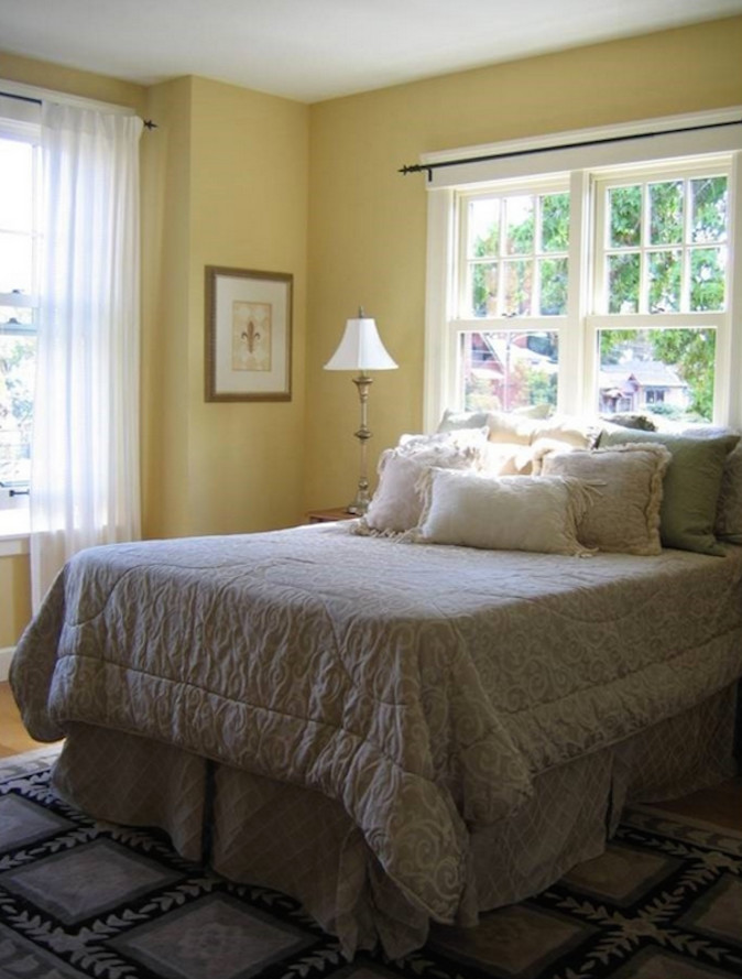 На фото: маленькая хозяйская спальня в стиле кантри с желтыми стенами и светлым паркетным полом для на участке и в саду с