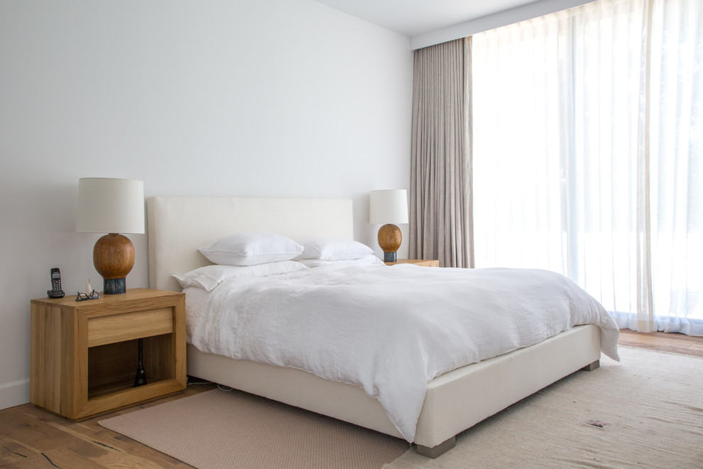 Foto de dormitorio principal tradicional renovado con paredes beige, suelo de madera en tonos medios y suelo beige