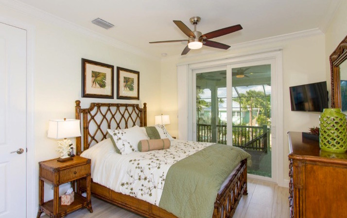 Foto de habitación de invitados costera de tamaño medio sin chimenea con paredes beige, suelo de madera clara y suelo beige