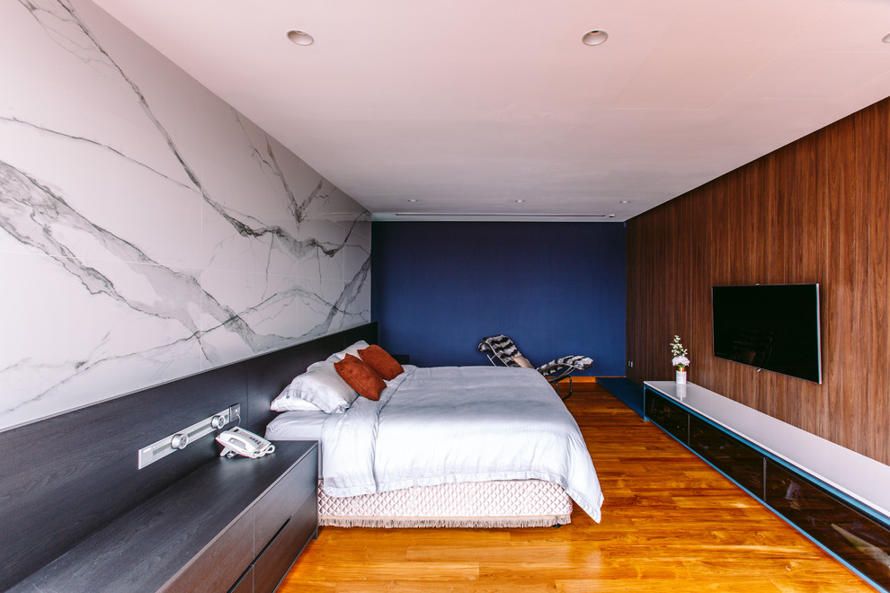 シンガポールにあるコンテンポラリースタイルのおしゃれな寝室 (青い壁、無垢フローリング、茶色い床、グレーとブラウン) のレイアウト