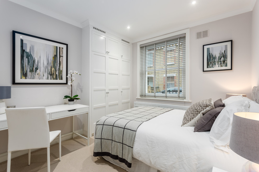 This is an example of a small contemporary master bedroom in London with grey walls and carpet.