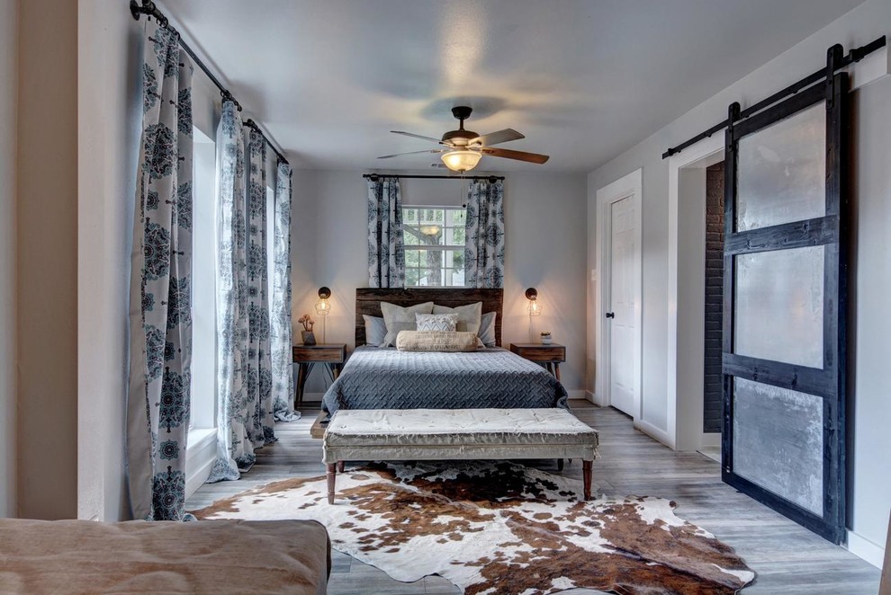 オースティンにある広いカントリー風のおしゃれな主寝室 (グレーの壁、無垢フローリング、グレーの床、暖炉なし)