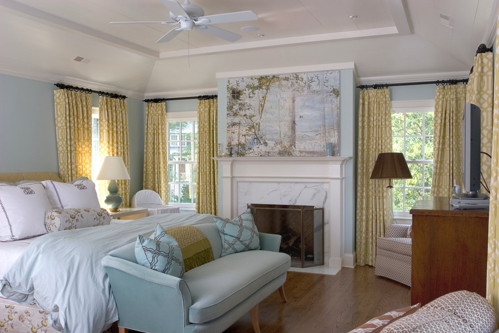 Idée de décoration pour une chambre tradition avec un mur bleu, un sol en bois brun et une cheminée standard.