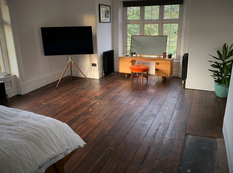 Example of an ornate master brown floor bedroom design in Hertfordshire with white walls