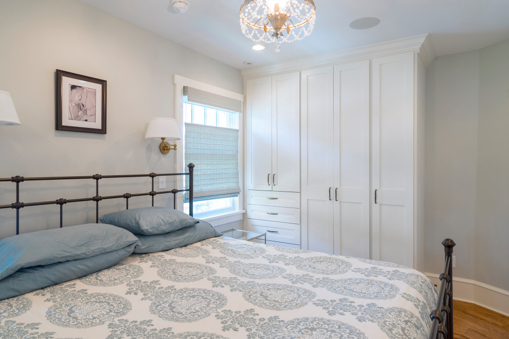 Imagen de dormitorio principal de estilo americano de tamaño medio con paredes grises, suelo de madera en tonos medios y suelo marrón