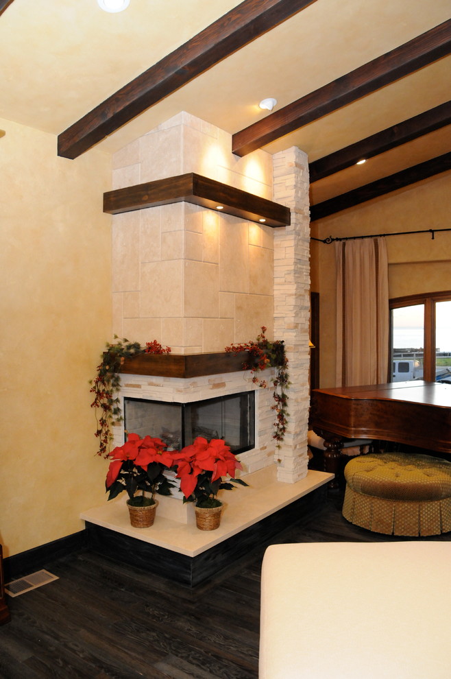 Aménagement d'une chambre parentale classique de taille moyenne avec un mur jaune, parquet foncé, une cheminée ribbon et un manteau de cheminée en pierre.