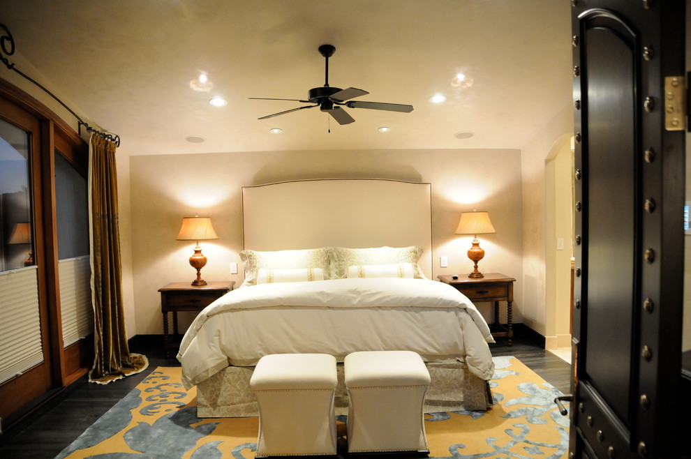 Стильный дизайн: хозяйская спальня среднего размера в классическом стиле с желтыми стенами, темным паркетным полом, горизонтальным камином и фасадом камина из камня - последний тренд
