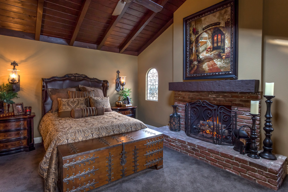 Mid-sized mountain style master carpeted and gray floor bedroom photo in Orange County with a standard fireplace, a brick fireplace and beige walls