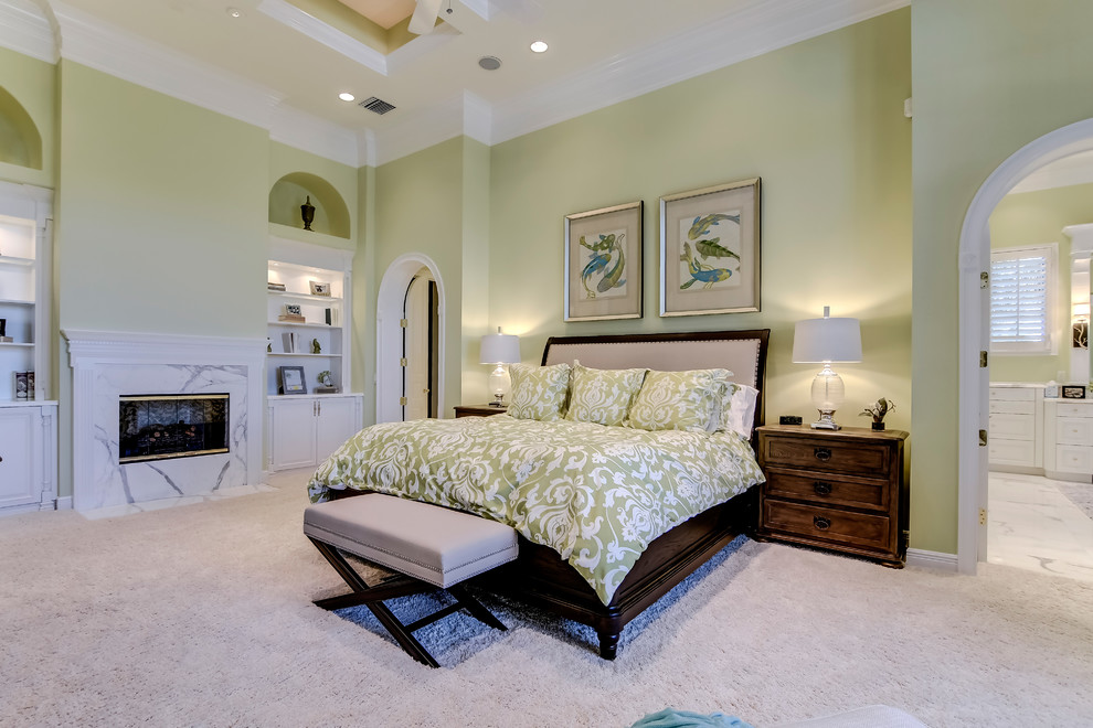 Foto de dormitorio principal clásico renovado grande con paredes verdes, todas las chimeneas, marco de chimenea de piedra y moqueta