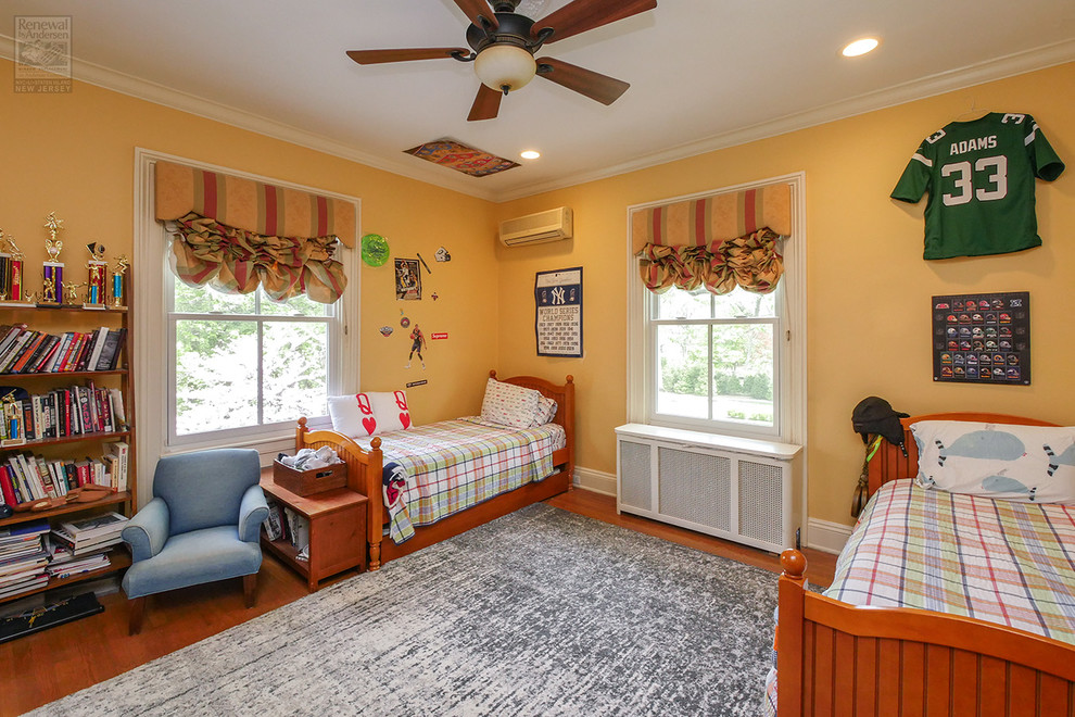 Large medium tone wood floor and multicolored floor bedroom photo in Newark with yellow walls and no fireplace