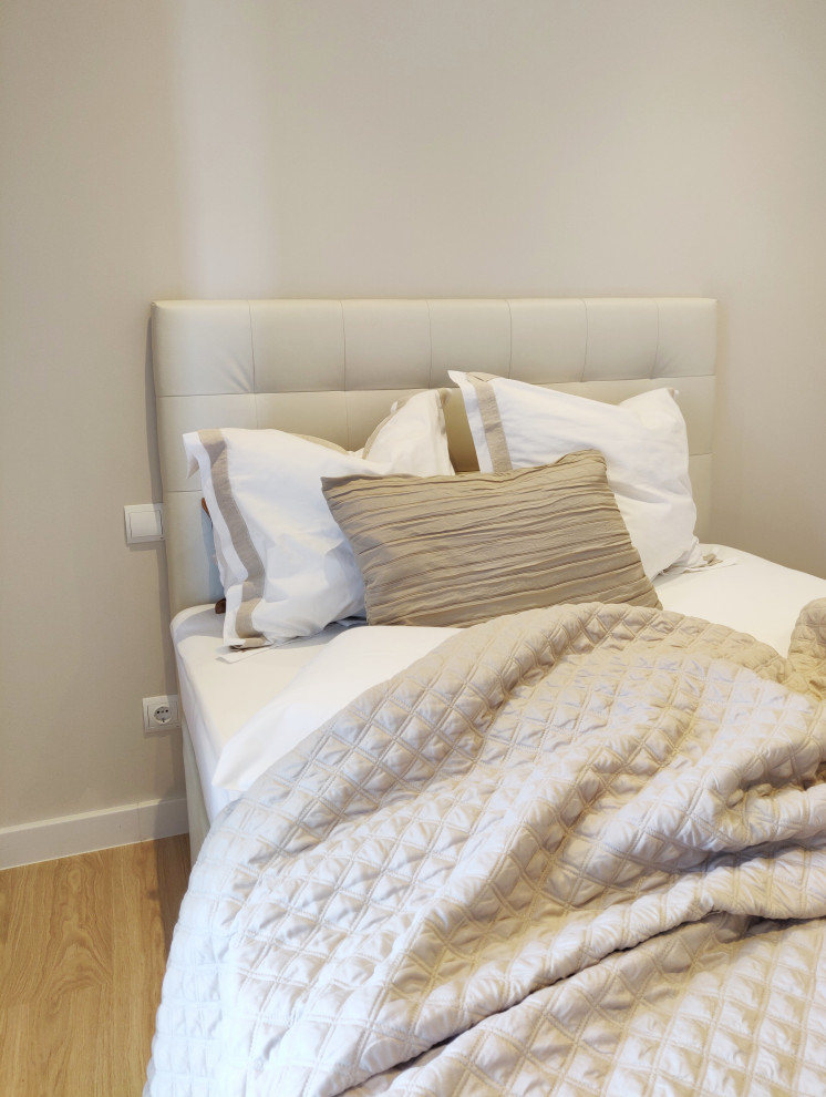 Idee per una camera degli ospiti minimal di medie dimensioni con pareti beige e parquet chiaro
