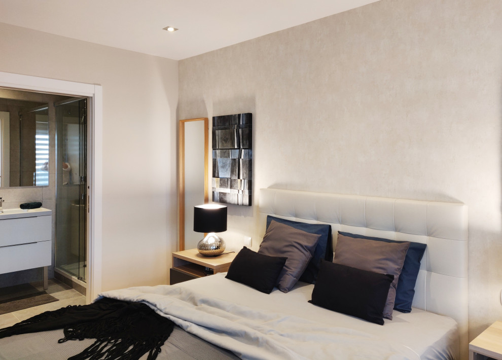 Imagen de dormitorio principal contemporáneo de tamaño medio con paredes beige y suelo de madera clara