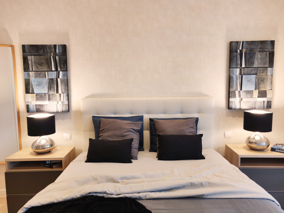 Foto de dormitorio principal actual de tamaño medio con paredes beige y suelo de madera clara