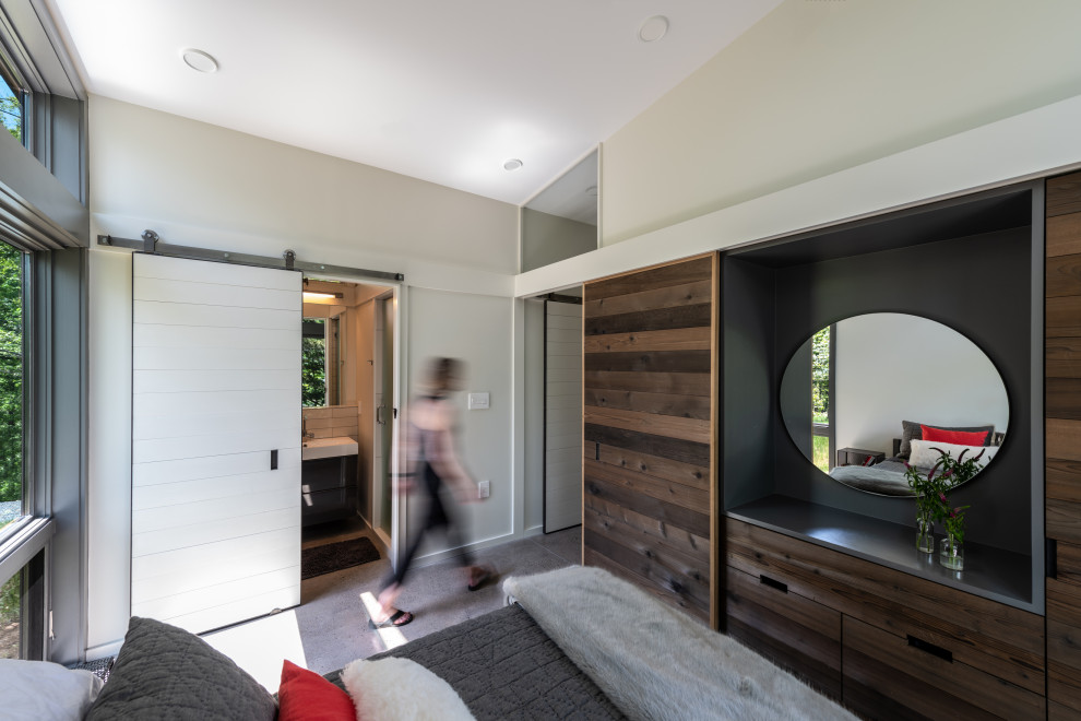 Foto de dormitorio principal minimalista pequeño con suelo de cemento, marco de chimenea de hormigón y suelo gris