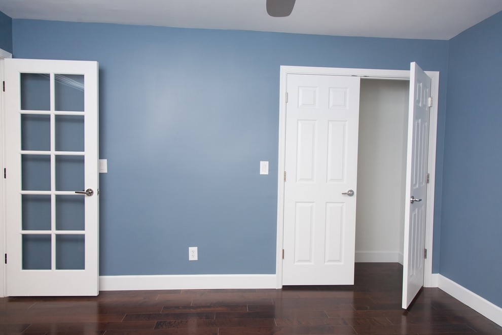 Diseño de habitación de invitados tradicional de tamaño medio sin chimenea con paredes azules y suelo de madera oscura