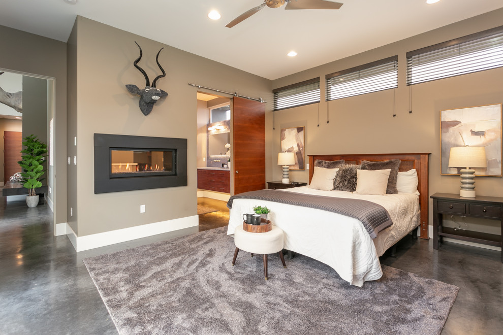 Modernes Hauptschlafzimmer mit beiger Wandfarbe, Betonboden, Gaskamin und grauem Boden in Seattle