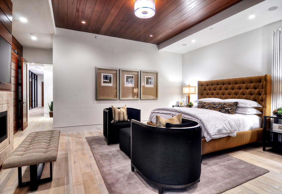Foto de dormitorio contemporáneo con paredes grises, suelo de madera clara y chimenea lineal