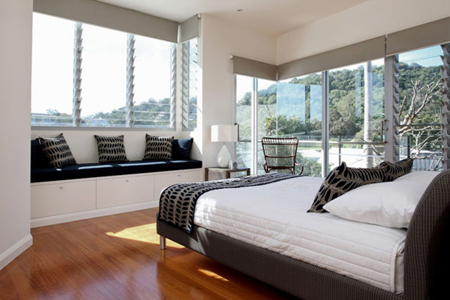 Maritimes Schlafzimmer mit weißer Wandfarbe und braunem Holzboden in Brisbane